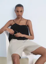 Top negro de viscosa con tirantes finos ajustables, escote recto y diseño crop estilo globo, con forro interior de poliéster.