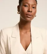 Blazer celeste de viscosa y lino, con cuello inglés, cierre de un botón y solapas.