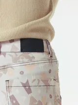 Pantalón de jean de tiro medio con corte de pierna recta y ajuste cómodo. Presenta un estampado integral con motivos geométricos y abstractos en tonos azules.