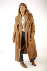 Tapado largo color camel, con solapas clásicas, cierre frontal con lazo ajustable y detalles de trabillas en los puños.