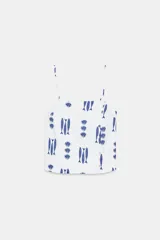 Top de escote recto con tirantes finos ajustables, estampado con motivos marinos de peces y conchas en color azul sobre fondo blanco. Presenta detalle de botones decorativos en el frente y aberturas en el bajo.