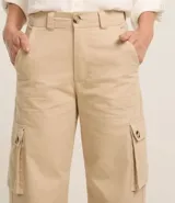 Pantalón de sarga color beige, de corte wide leg, con bolsillos cargo laterales y cintura alta.