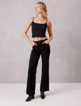 Jean wide leg marca Elan, color negro, de tiro alto con pierna ancha desde la cadera hasta el ruedo. Incluye pretina con pasadores, botón y cierre, y bolsillos funcionales en la parte delantera y trasera. La terminación del ruedo es deshilachada.