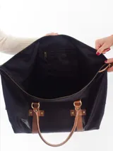 Bolso de viaje tipo duffle, confeccionado en cuero natural color azul con textura, con detalles de correas y asas en cuero color suela. Cuenta con cierre superior, bolsillo interior con cierre y compartimento para celular.