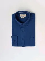 Camisa de manga larga azul, de lino y poliéster, con cuello abotonado y bolsillo en el pecho.