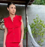 Top rojo sin mangas tejido en hilo de algodón, con cuello mao y volados en los hombros.