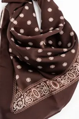 Pañuelo tipo bandana de color marrón con estampado paisley en los bordes y lunares blancos en el centro.
