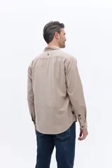 Camisa de pana de algodón con cuello clásico, cierre frontal de botones y mangas largas. Presenta un diseño de corte regular con textura suave y acabado mate.