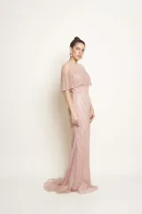Vestido largo de tul color rosado, con sobrecapa corta y diseño entallado, íntegramente bordado con perlas y piedras.