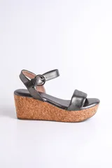 Sandalia plateada con plataforma de corcho, diseño cruzado y tira con hebilla al tobillo.