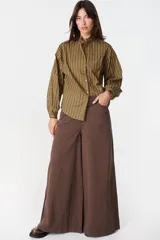 Jean de corte wide leg en color bordó, confeccionado en denim de algodón. Presenta tiro medio, bolsillos traseros amplios y una silueta holgada y fluida.