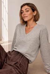 Sweater tejido de punto melange color bordó, con escote en V y mangas largas.
