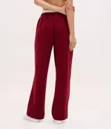 Pantalón deportivo de corte recto, confeccionado en tejido de microfibra color bordó. Presenta cintura elástica con cordón ajustable, bolsillos delanteros embutidos y detalle de bordado discreto en la pierna.