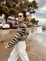 Campera puffer cropped color verde militar con mangas y capucha de polar estampado con cebra en blanco y negro.