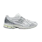 Championes New Balance modelo 1906R, de diseño técnico y deportivo en tonos gris, blanco y plateado, con detalles en verde lima. Presenta una estructura de malla transpirable con refuerzos sintéticos y entresuela amortiguada.