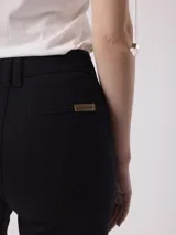 Pantalón jean color beige, de tiro alto y pierna ancha con terminación desflecada.