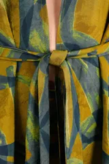 Kimono fluido con estampado abstracto en tonos mostaza y verde azulado, con mangas tres cuartos y lazo ajustable en la cintura.