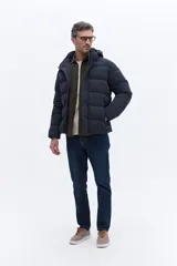 Campera puffer con capucha integrada, cierre frontal cubierto y bolsillos laterales. Confeccionada en nylon, presenta un diseño acolchado y funcional ideal para climas fríos.