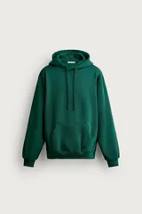 Sudadera hoodie relaxed fit color verde oscuro, confeccionada en tejido de algodón con interior cepillado, capucha ajustable con cordón y bolsillo frontal tipo canguro.