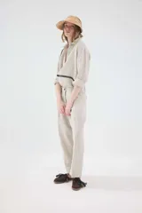 Camisa de lino blanca, de silueta oversize y calce relajado, con mangas largas y detalles de puntillas en la delantera.