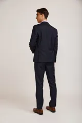 Ambo de vestir para hombre compuesto por saco de dos botones y pantalón de corte recto, en color azul marino. El saco presenta solapas clásicas y bolsillos con solapa, mientras que el pantalón cuenta con un ajuste entallado.