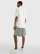 Camisa blanca de manga corta confeccionada en popelín de puro algodón, con cuello abotonado, corte regular y logo de Tommy Hilfiger bordado en el pecho.