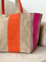Bolso tipo shopper de diseño amplio, confeccionado en gamuza con un patrón de franjas verticales en tonos marrón oscuro, rosa y verde oliva. Cuenta con doble asa de hombro y cierre superior.
