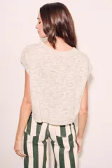 Chaleco de punto color crema con detalles en rosa y celeste, de corte holgado y mangas cortas.