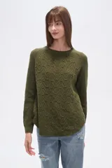 Sweater de algodón color verde oliva con textura de punto en zigzag y motas de colores. Presenta cuello redondo y mangas largas tipo ranglán, con calce holgado.