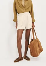 Short de corte holgado color lila, con cintura elástica y dos bolsillos frontales amplios.