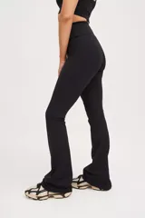 Calza larga negra de compresión media con cintura cruzada y corte acampanado.