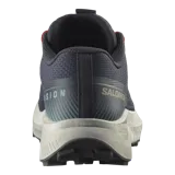 Championes de trail running Salomon Vision color gris oscuro, con detalles en rojo en los cordones, suela blanca y amortiguación texturizada.