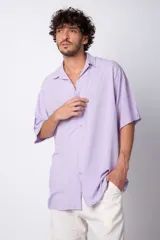 Camisa de manga corta con cuello cubano, confeccionada en fibrana premium. Presenta un corte oversize y cierre frontal con botones al tono.