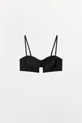 Sujetador negro de corte strapless con escote corazón y abertura central. Posee tirantes finos ajustables y removibles.