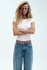 Jeans wide leg de tiro alto, color azul con efecto deslavado, cintura con trabillas, diseño de cinco bolsillos y cierre frontal con cremallera y botón metálico.
