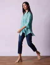 Camisa celeste con estampado de cachemir en blanco, cuello a la base, escote en V y abertura central con botones. Terminación de ruedo asimétrico. Manga 3/4 de largo regulable con presilla y botón.