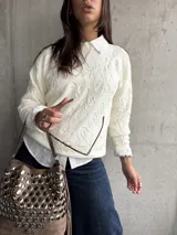 Sweater de punto color natural con diseño de relieve floral en toda la prenda, cuello redondo y mangas largas con puños acanalados.