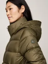 Campera puffer verde militar de Tommy Hilfiger, con capucha ajustable, cierre frontal con cremallera, dos bolsillos delanteros con botón a presión y parche con el logo de la marca en la manga.