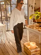 Pantalón negro de cuero ovino italiano, corte mom fit con tiro semi alto y tajos inferiores.