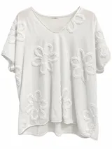 Remera blanca de manga corta con cuello en V y apliques de flores texturizadas en relieve distribuidas por toda la prenda.