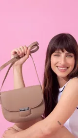 Bandolera de símil cuero color marrón claro, con tapa y presilla con broche metálico plateado. Tiene correa extensible.