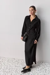 Camisa blanca de manga larga con textura suave y caída liviana, cuello camisero, puños anchos y fruncidos sutiles en los hombros.