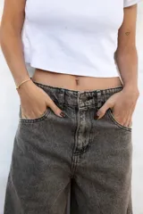 Jean de mujer color gris oscuro con efecto acid wash, de corte holgado y tiro bajo.