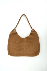 Bolso de gamuza marrón, estilo hobo, con correa para el hombro y detalles de argollas metálicas.