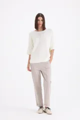 Pantalon de vestir color visón, de corte recto y tiro medio, con costura central decorativa y botamanga con dobladillo.