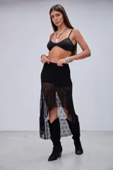 Pollera larga de encaje negro con volados asimétricos y forro corto.