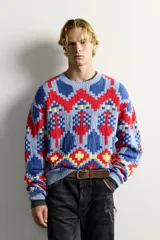 Jersey de punto tejido en hilatura de algodón, con diseño de patrones geométricos en colores celeste, azul, rojo y amarillo. Presenta cuello redondo, manga larga y acabados en rib.
