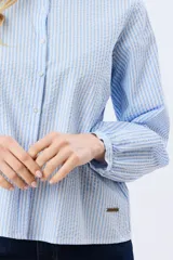 Camisa rayada de manga larga, confeccionada en algodón, con cuello mao y cierre frontal de botones.