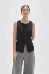 Chaleco sin mangas de corte sastrero, color marrón con diseño de rayas verticales finas. Presenta cuello redondo, cierre frontal con botones y dos bolsillos laterales simulados.