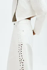 Jean de corte recto confeccionado en denim de algodón blanco, con bolsillos laterales y detalles de broderie en los laterales de las piernas y en el bajo.